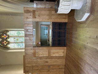 Wooden panelled room with barn doors, housing kitchen units and sink.