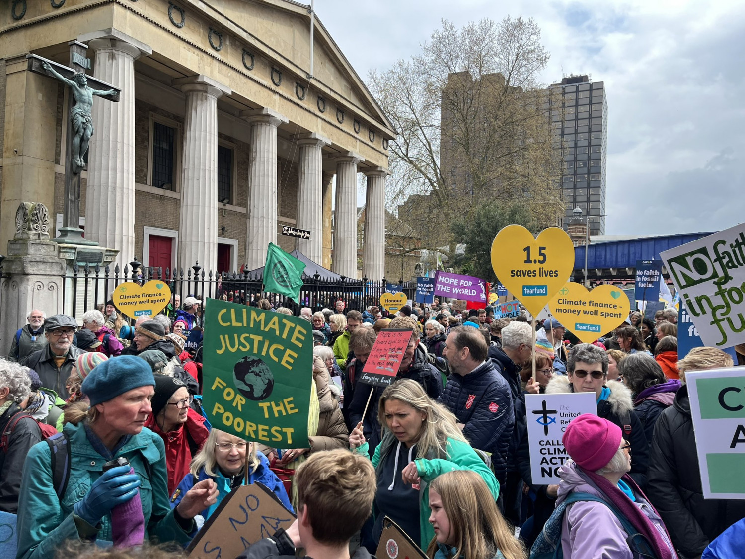 Photo showing crowd of protesters with placards reading 'Climate justice for the poorest'.