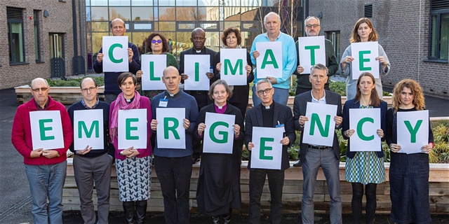 Diocese staff hold Climate Emergency sign